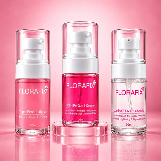 Three FLORAFIX skincare pump bottles in a clean studio setup on a pink gradient background. The center bottle sits on a clear acrylic riser.